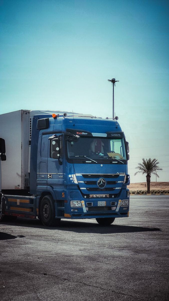 Heavy-duty white truck at a transport yard